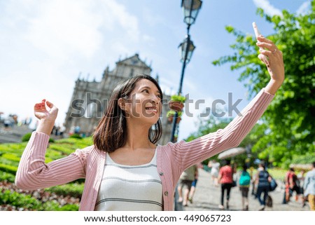 Woman taking selfie with Saint Paul's Cathedral in Macau