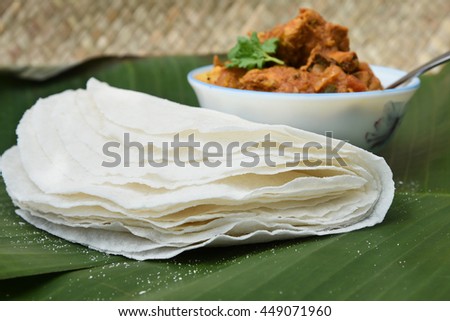 Rice pathir/Pathiri flat bread with spicy chicken curry, Kerala India. Popular traditional South Indian breakfast/dinner dish of Malabar Muslims. Eaten with side dish on Ramadan/Ramzan, Eid festival.