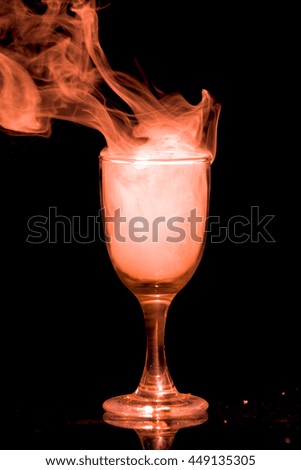  glass with a orange smoke on a black background