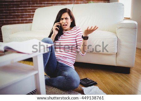 Beautiful young woman talking on phone at home Royalty-Free Stock Photo #449138761