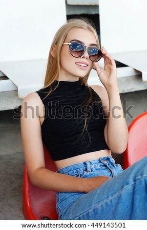 Hipster girt posing at the stadium. Outdoors lifestyle portrait