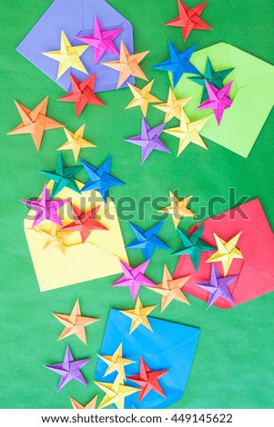 Colorful origami stars for christmas on green