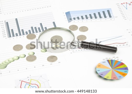 Business still-life of a diagram, magnifier, coins