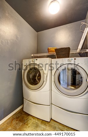 Laundry room with tile floor, blue walls, washer, and dryer.