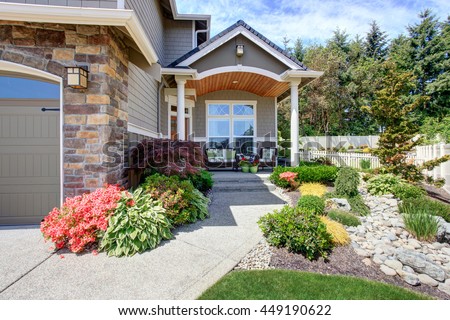 Home exterior with garage and driveway, patio area with nice landscaping desing around Royalty-Free Stock Photo #449190622