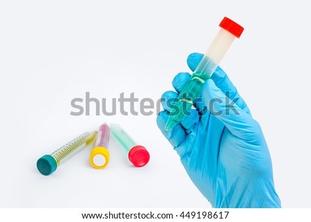 Scientists hand holding a test-tube with cyan liquid on gray background