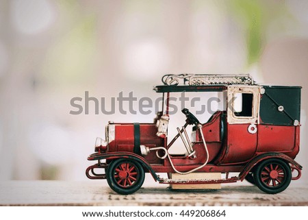 red vintage toy car on wooden table