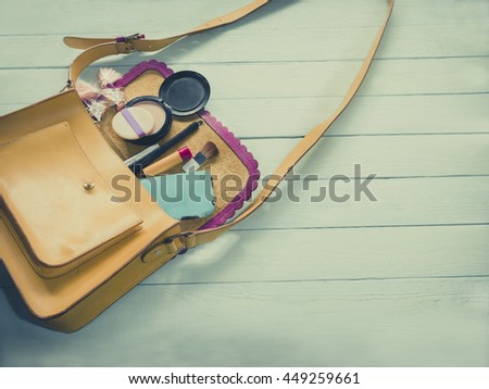 Female bag with smart phone and cosmetics-pastel background