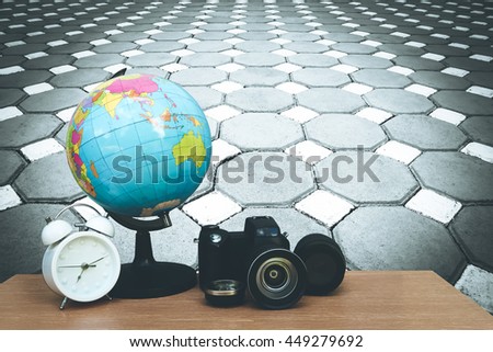 globe ,clock and camera on desk with perspective brick floor background