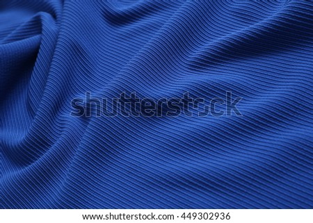 blue wrinkled textured stretch fabric lies on the floor