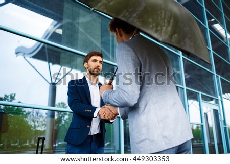 Picture of  two young businessmen meeting at station background 