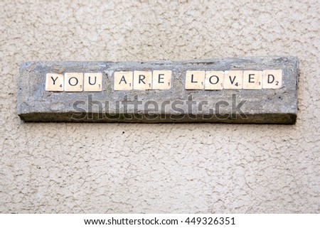 a custom made sign with the message "you are loved"