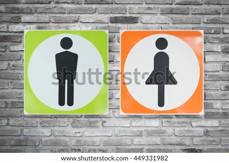 A man and a lady toilet sign on old brick wall.
