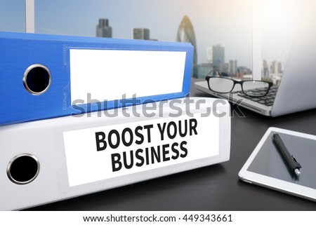 BOOST YOUR BUSINESS Office folder on Desktop on table with Office Supplies.