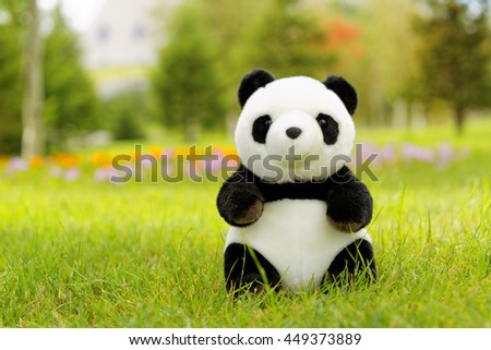 toy panda on the green grass 