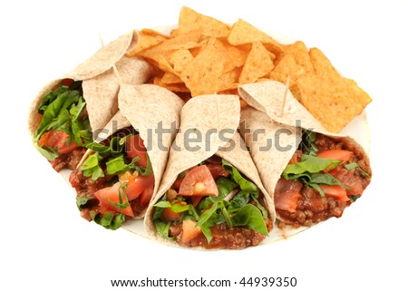 Delicious and colorful mexican fajitas or wraps, and crunchy nacho chips isolated on a white background
