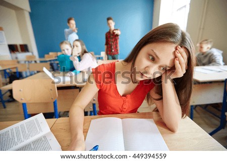 education, bullying, conflict, social relations and people concept - students teasing and judging girl classmate behind her back at school Royalty-Free Stock Photo #449394559