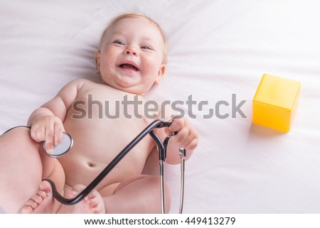 Baby is holding a stethoscope on a white background