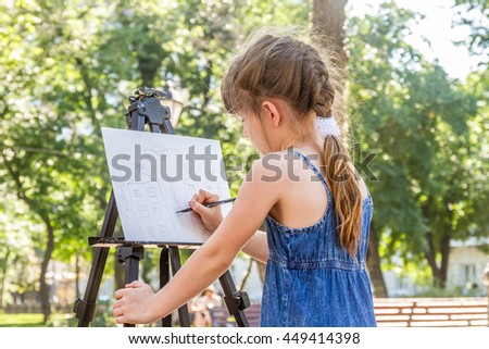 young happy child girl drawing a picture outdoors, kid painting