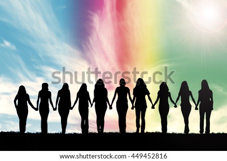 Silhouette of ten young women, walking hand in hand under a rainbow sky. Royalty-Free Stock Photo #449452816