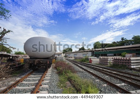 pile of concrete railroad tie with train as background