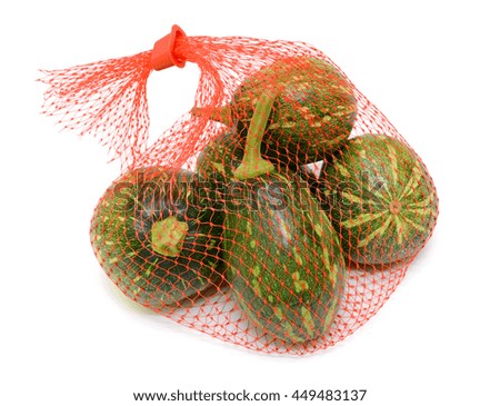 green pumpkin in mesh bag isolated on white background