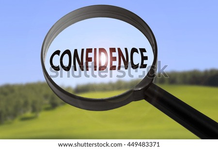 Magnifying glass with the word confidence on blurred nature background