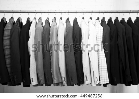Suits jacket hanging stacked on hanger,black and white Royalty-Free Stock Photo #449487256