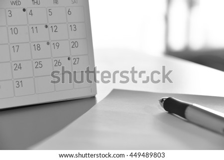 blurred calendar with pen in planning concept.