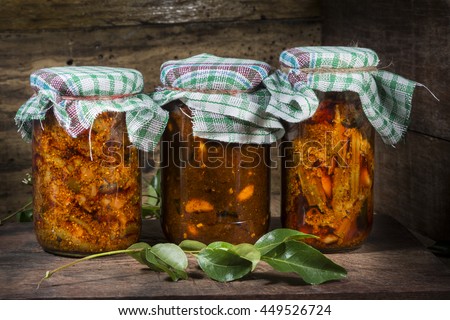 Jars of south Indian homemade pickle on wooden kitchen table  Royalty-Free Stock Photo #449526724