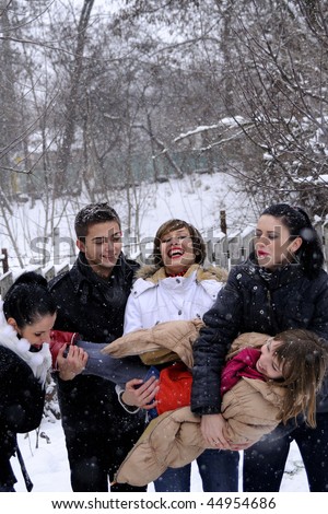 happy teenagers playing in snow