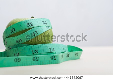 Diet and Health concept.Green apple and measuring tape 