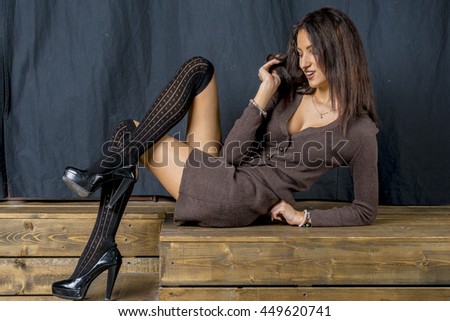 Beautiful brunette girl in black stockings cheerful smiles hamming
