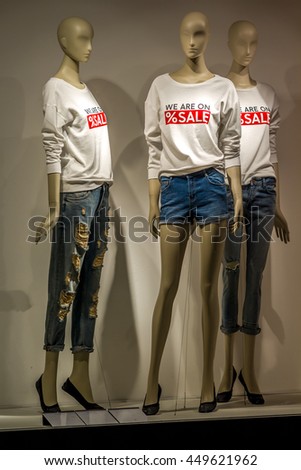Mannequins with sales t-shirts. Mannequins wear t-white shirts on which it is written sales with red.  