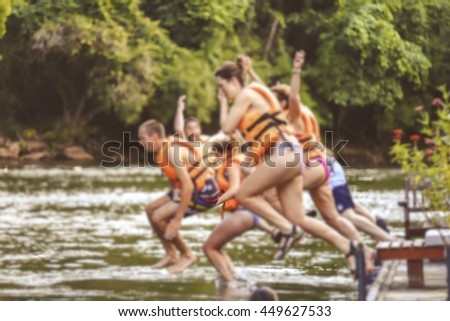 Blurred of group of friends jumping on the river kwai, Kanchanaburi during the vacation. Concept about vacations, leisure and fun
