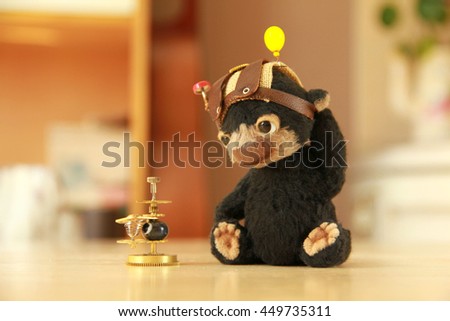 Photo of funny toy - Teddy Bear, the inventor speculates about space, looking at the equipment.