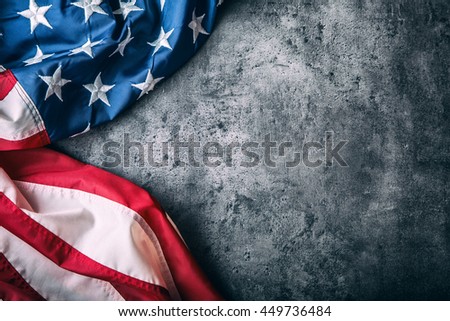 American flag freely lying on concrete background.