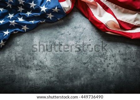 American flag freely lying on concrete background.