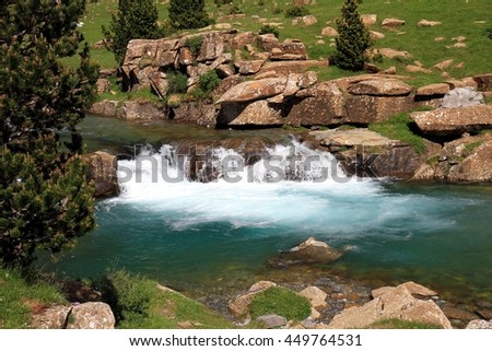 Prairie and waterfalls in the alpine landscape of Circo de Soaso in Pyrenees mountain range