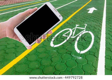 Man use mobile phone, blur image of bike way as background.