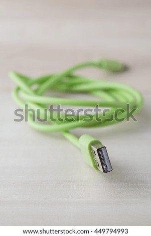 USB connector, USB cable charger for smartphone on wooden background.