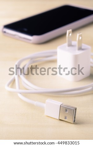 USB connector, USB cable charger for smartphone on wooden background.