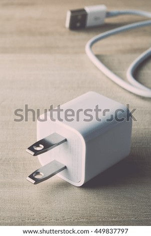 USB connector, USB cable charger for smartphone on wooden background, vintage color tone.