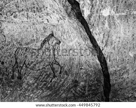 Abstract children art in sandstone cave. Black carbon paint of horses on sandstone wall, copy of prehistoric picture. 