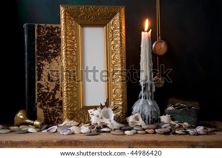Picture gold frame and candle .Still-life.