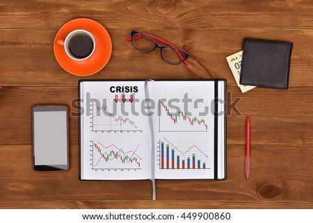 crisis concept drawing in note pad and business elements on a desk