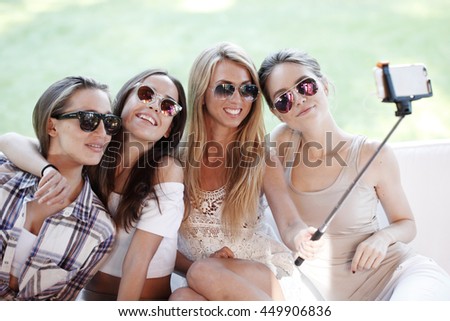 Young beautiful female friends taking selfie outdoors