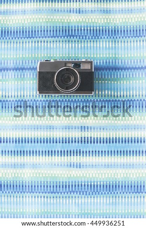 Vintage photocamera on blue paper background. 