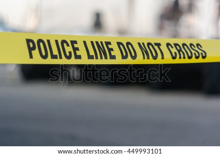 Yellow police tape with text: police line do not cross cornering off area from public access Royalty-Free Stock Photo #449993101