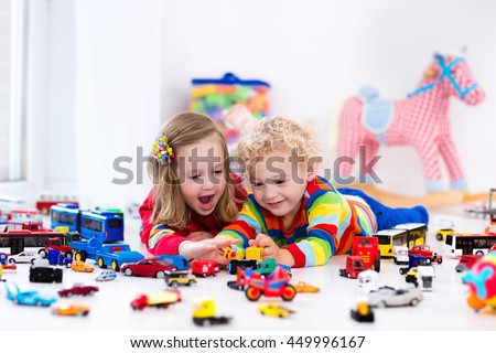 Little toddler boy and girl playing with model car collection on the floor. Transportation and rescue toys for children. Toy mess in child room. Many cars for little boys. Educational games for kids. Royalty-Free Stock Photo #449996167